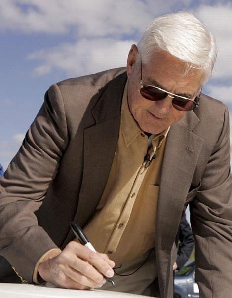 General Motors Vice Chairman Bob Lutz puts his stamp of approval on the hood of the first Chevrolet Volt engineering development vehicle after reaching speeds of nearly 60 mph while test driving it at the GM Proving Grounds.